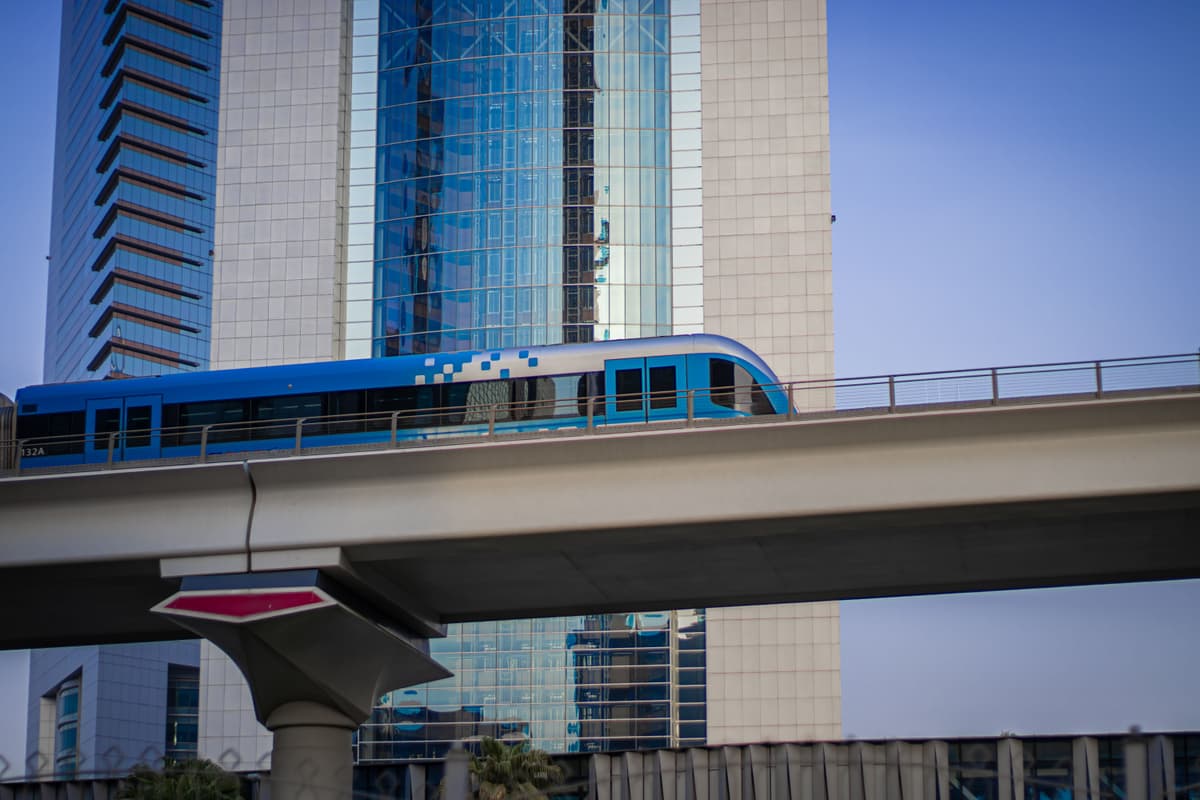 Dubajské metro přijízdí k zastavře mezi mrakodrapy — jedno z nejmodernějších městských dopravních systémů na světě